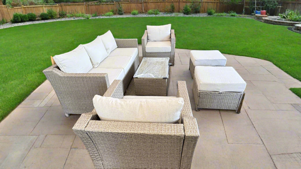 Outdoor patio furniture set with beige cushions on a stone patio