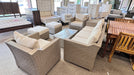 Outdoor furniture set with beige cushions on a showroom floor.